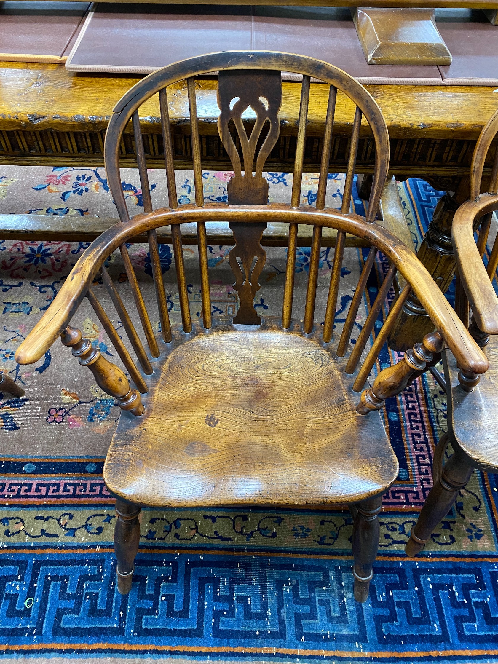 A near pair of mid 19th century yew and elm Windsor elbow chairs, with crinoline and H stretcher, larger width 64cm, depth 48cm, height 87cm